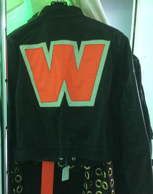 10 DE GETEKENDE RUG RECLAME Iemand die een jas draagt met een grote letter W erop, laat zien dat hij kleding draagt van de bekende