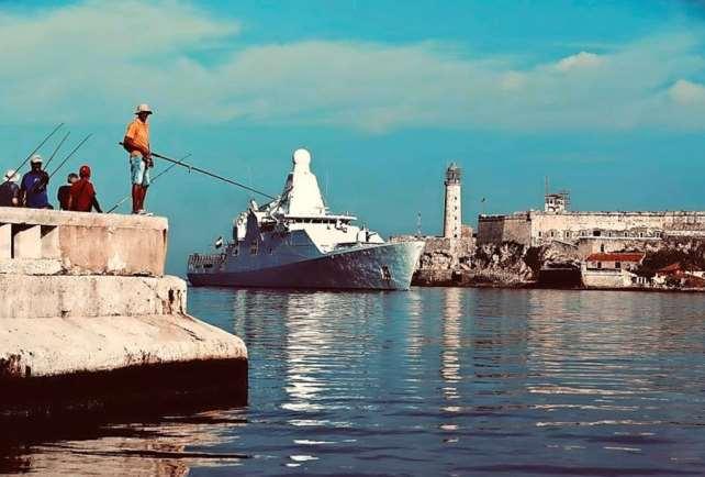 Het Nederlandse oorlogschip passeert de havenhoofden van Havana Net als tijdens het bezoek van Zr.Ms. Holland aan New York in juli, leverde dit havenbezoek sfeervolle beelden op.