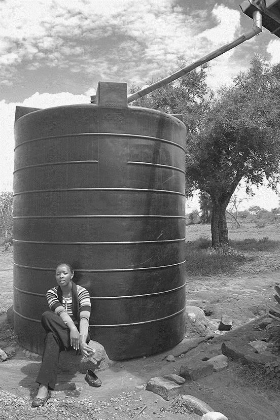 De school krijgt er nog een watertank bij. Op de foto zie je deze watertank. Deze watertank heeft de vorm van een cilinder, een straal van 1,10 m en een inhoud van 10 000 liter.