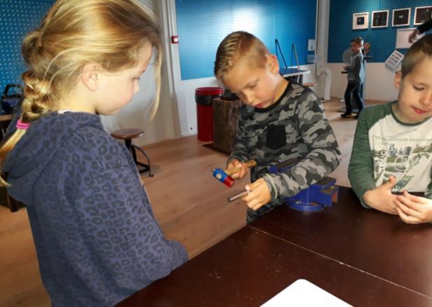 De kinderen volgden daar de les het ambacht van de zilversmid.