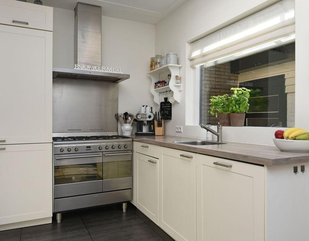 De uitbouw biedt ruimte voor de L-vormige keuken die voorzien is van SMEG apparatuur zoals een