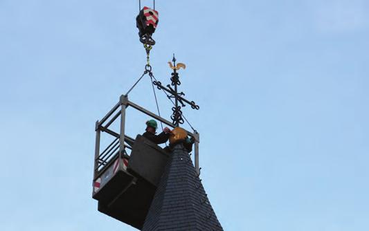 18 Het kruis, bol en haan van de torenspits van onze kerk worden na een vier maanden durende restauratie met een torenhoge kraan teruggeplaatst.