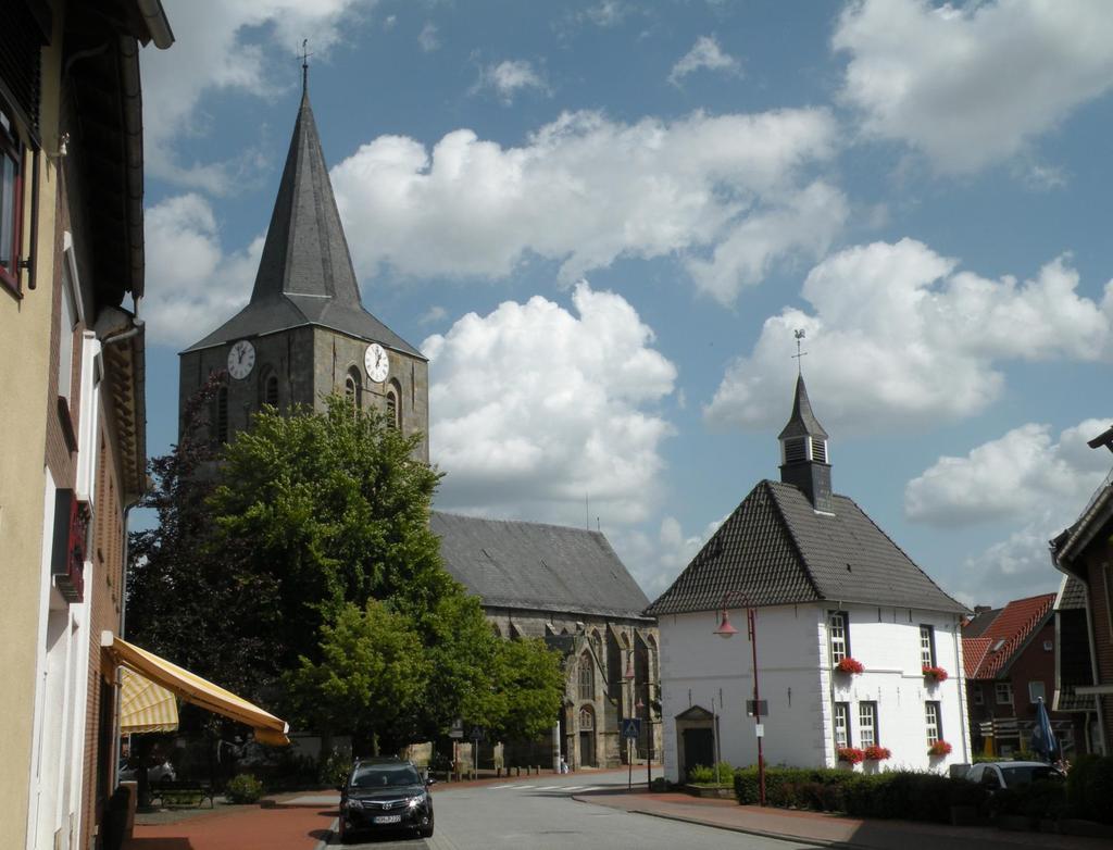 Uelsen, Duitsland, kerk en voormalig gemeentehuis (nu VVV-kantoor), 16 August 2012. Bron: Wikipedia. Zie II.
