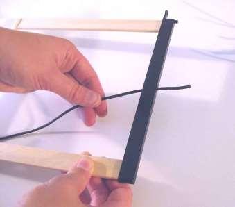 Rijg een elastiek vanaf de binnenkant door het gat in de schachtzijde en trek de knoop in de holte van de schachtzijde.