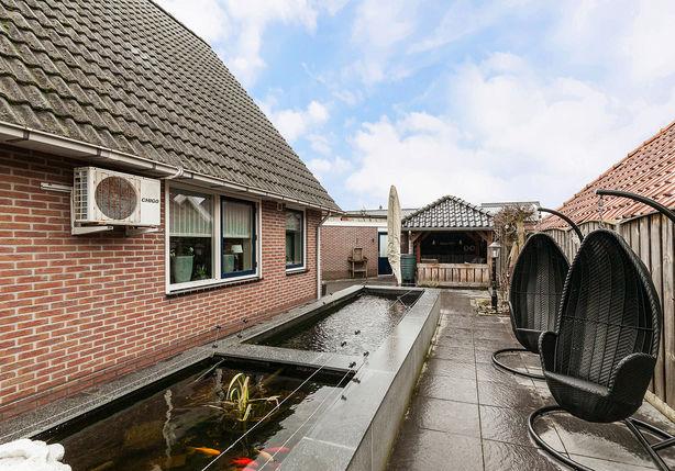 De woning beschikt tevens over een grote carport met garage/