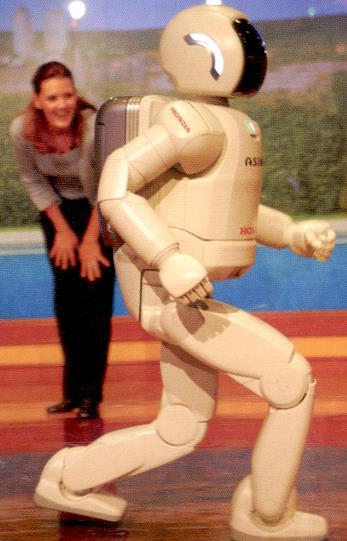 Lees de uitleg over robot Asimo. Dit is ASIMO. ASIMO is een robot. Er is al meer dan 25 ar aan ASIMO gewerkt. Eindelijk kan ASIMO een beetje rennen.