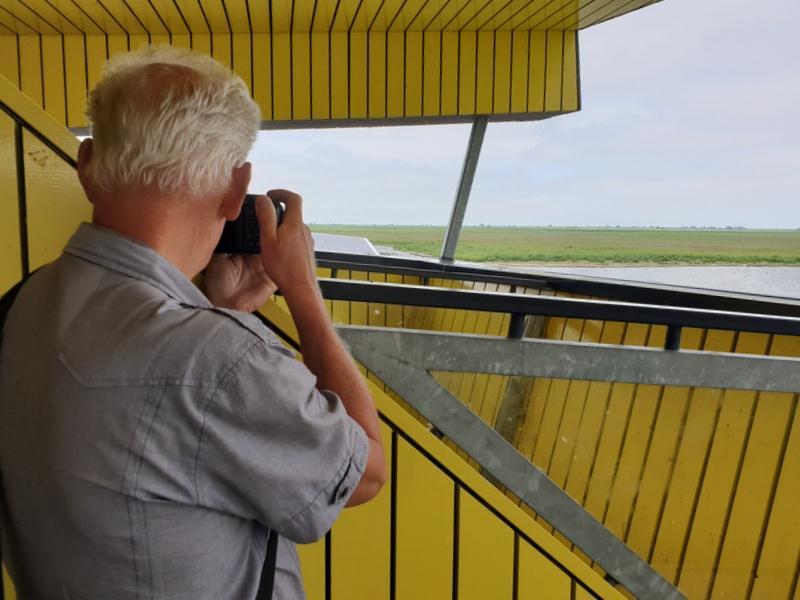 In Almere keken we vanaf het dak van het bezoekerscentrum van de Oostvaardersplassen uit over het uitgestrekte gebied. In het water foerageerden enkele Lepelaars.