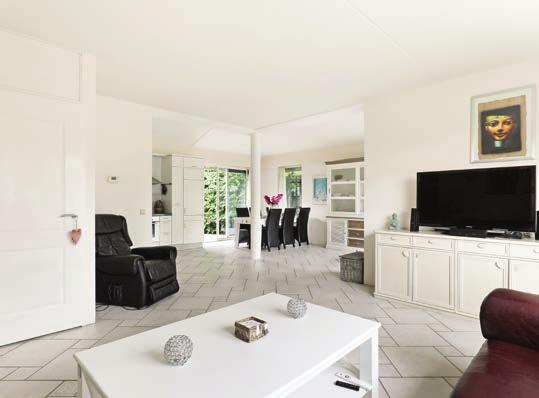 De ruim opgezette woonkamer is heerlijk licht en keurig afgewerkt met een mooie plavuizen vloer en keurige witte wanden!