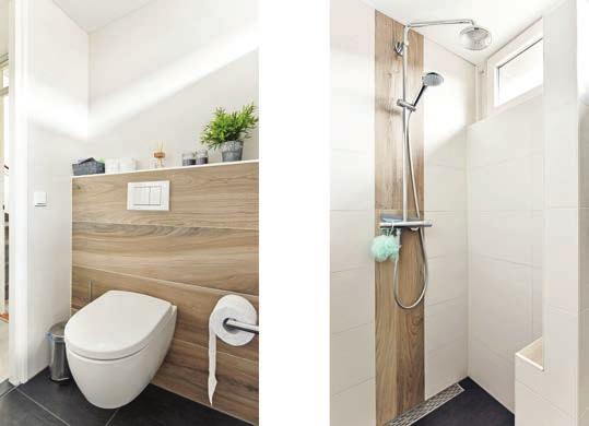 De badkamer is van goed formaat en oogt verzorgd dankzij de witte betegeling tot