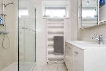 De badkamer is voorzien van royale inloopdouche, designradiator en badmeubel met enkele