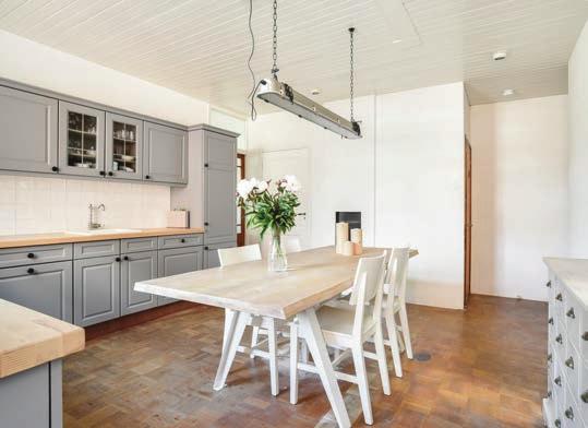Het is een ruime leefkeuken met een keukenblok in een moderne landelijke stijl waar heerlijke avondmaaltijden