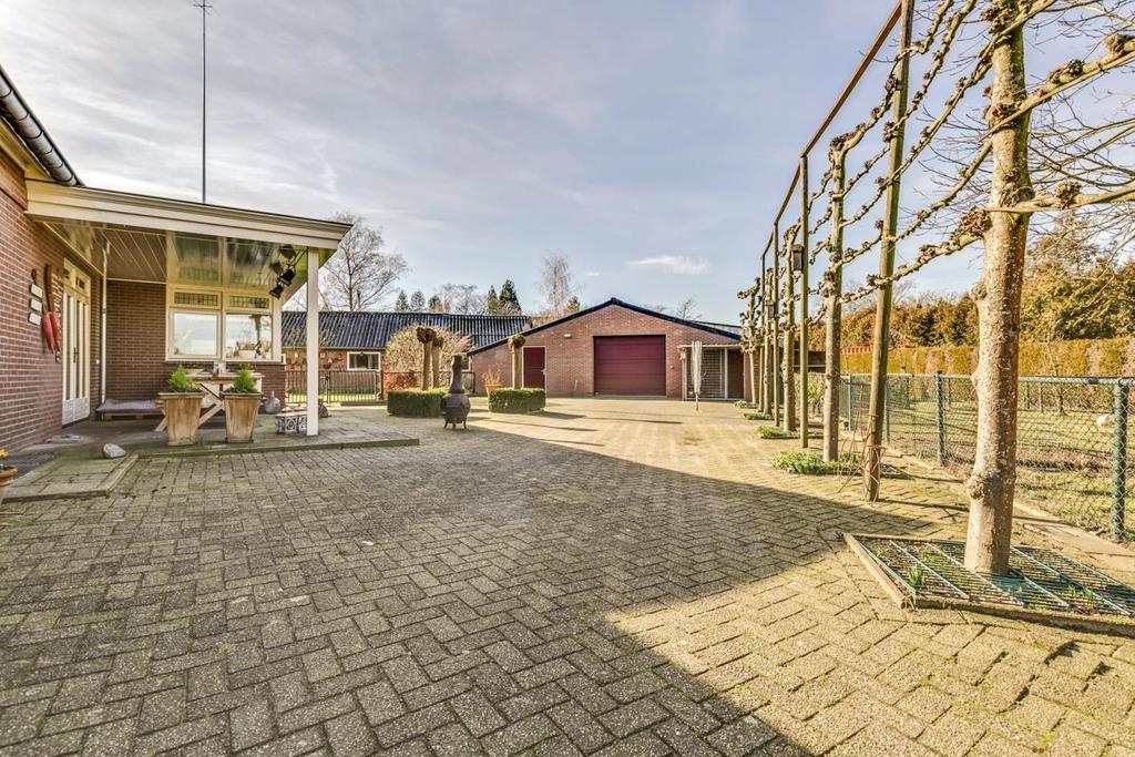 Tuin De zeer ruime tuin beschikt over een terrasoverkapping, bestrating, diverse bomen, hagen, vaste beplanting en diverse weilandjes.