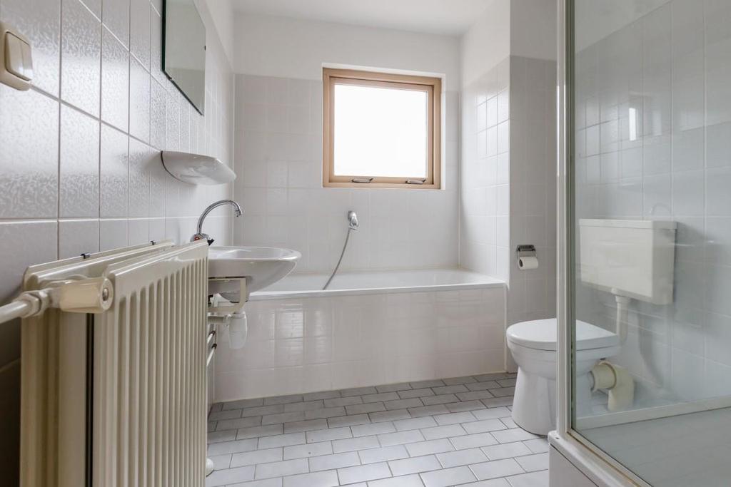 De badkamer: De licht betegelde badkamer is voorzien van een douchecabine, een wastafel, een ligbad en