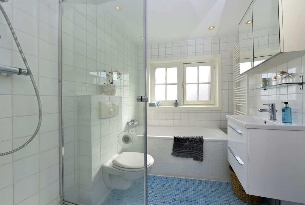 Bad- en slaapkamer De wit/blauw betegelde badkamer is modern en