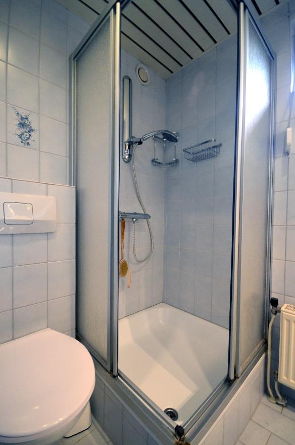 De volledig betegelde badkamer (3,5m²) is voorzien van een douche,