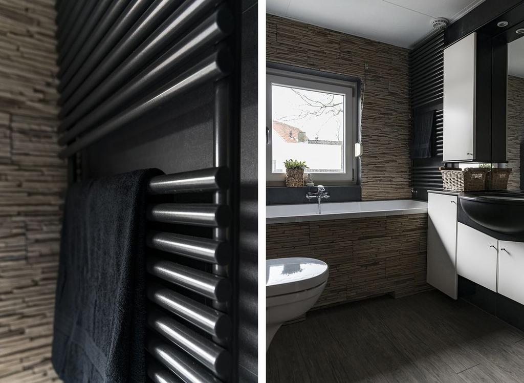 De luxe badkamer heeft een ligbad met handdouche, designradiator,