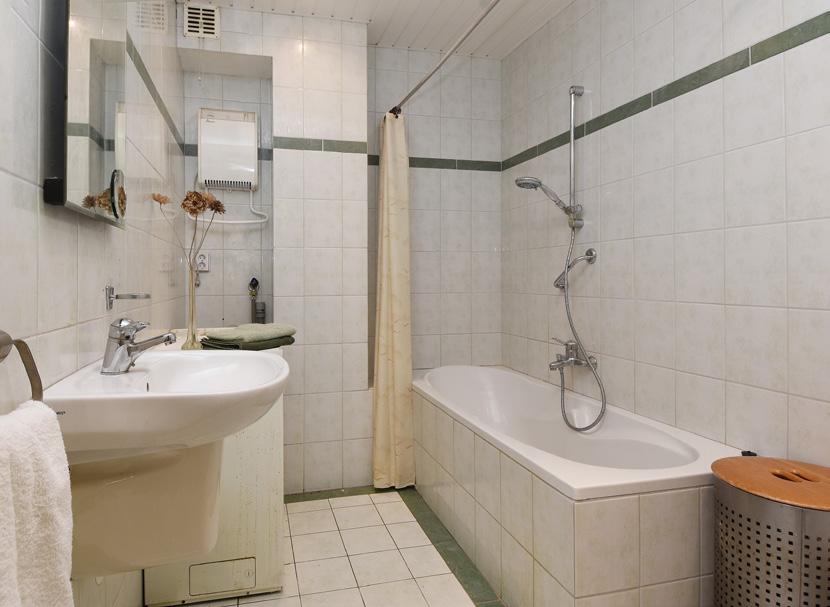 Badkamer Geheel betegelde badkamer met een ligbad,