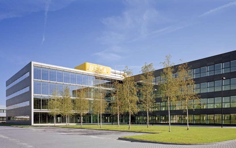 natuursteen. The building is a predominantly closed volume with a transparent core.