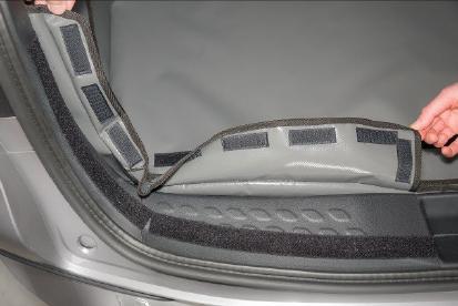 Bevestig het klittenband langs de bovenrand van de kofferbakbescherming direct op de eerder bevestigde tabbladen en langs de
