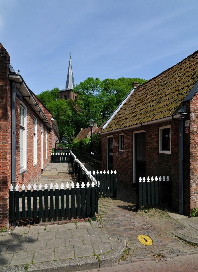 De kerk en een deel van de gracht van het voormalige stateterrein (links op de foto) in Metslawier.