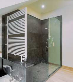 In deze ruime badkamer werd gebruik gemaakt van twee degelijke, natuurlijke materialen: teakhout en blauwe hardsteen.