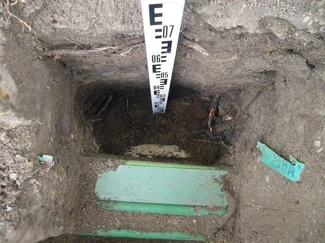 Foto 10: Kabels en leidingen bij gewone beuk onder trottoir De tweede profielkuil is op 2,4 m ten westen van de stamvoet gegraven in het trottoir.