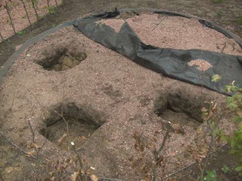 Nadat de beplanting is geplaatst worden de cirkels en het padje rondom de kapel uitgegraven. De afboording hiervan wordt uitgevoerd met gegalvaniseerde platen met een hoogte van 15 cm.