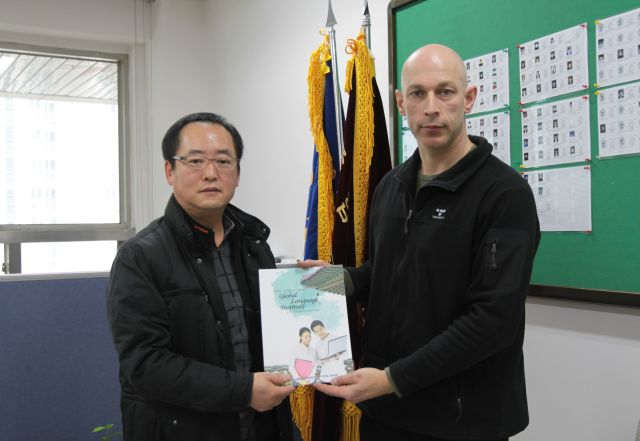 Professor Choi Bang Ho overhandigt meester Guy een van de eerste exemplaren van de Korean Language Course.