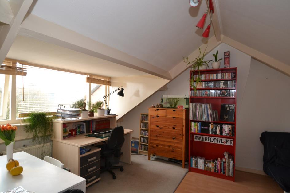 De woonkamer/slaapkamer is ca. 3.70x 5.15 m. (4.50 m. op de 1.50 m.-lijn) en heeft lichtinval middels een ruim dakkapel. De vloer is voorzien van laminaat. In de ruimte is t.v.-aansluiting aanwezig.