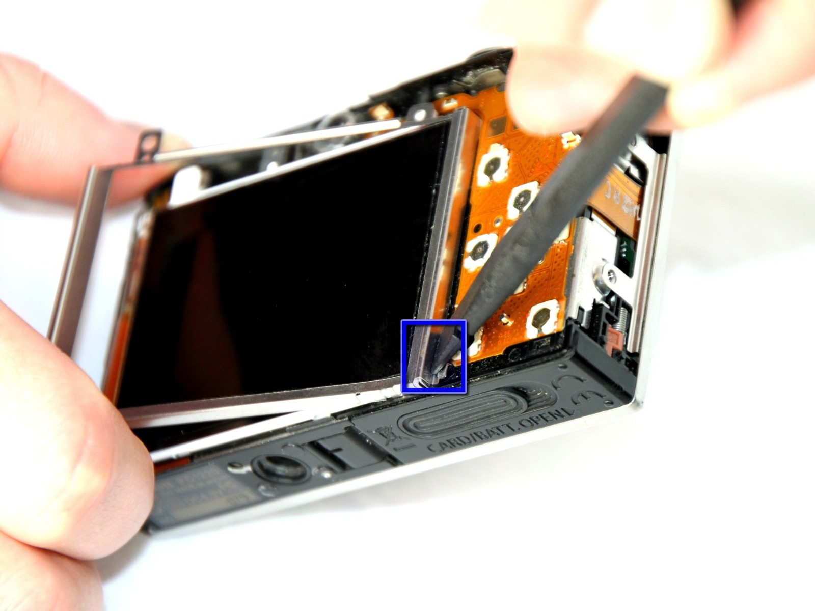Stap 9 Trek het metalen frame rond LCD-scherm vanaf de zijkant van de camera. Stap 10 Duw het metalen frame uit de buurt van het tabblad metalen met behulp van de spudger, aan het frame los te maken.