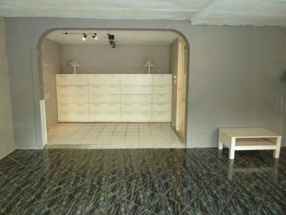 50 m²) is voorzien van een zwart/antraciet gestreepte tegelvloer en gipswanden.