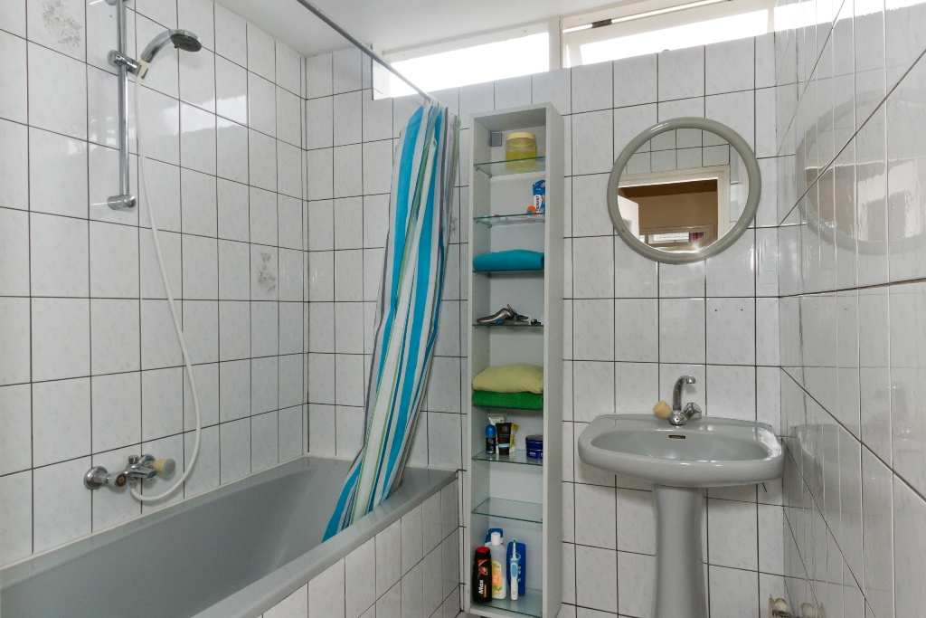 De badkamer: De badkamer tot het plafond betegeld met een lichte tegel en heeft een raam ten behoeve van de ventilatie.
