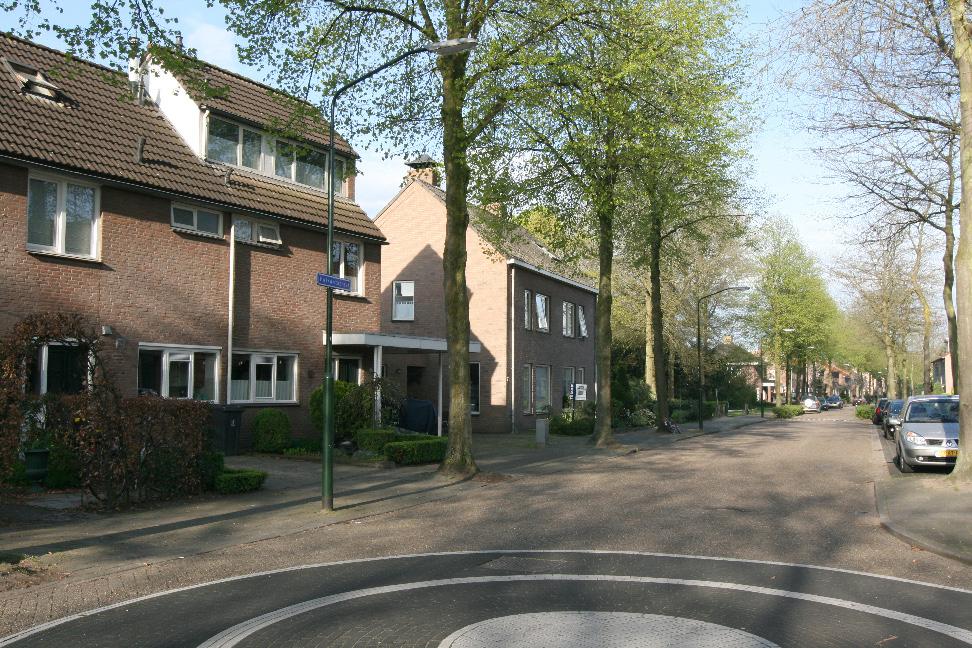 oprit met carport voor 1 auto. Via de poort achterin de tuin bereikt men een parkje.