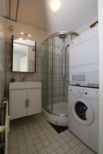 badkamermeubel met spiegelkastje, radiator en wasmachine/droger aansluiting.