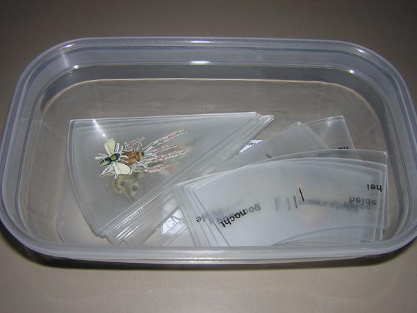 plexiglazen stukken in een doos met roze deksel, ronde witte schijf