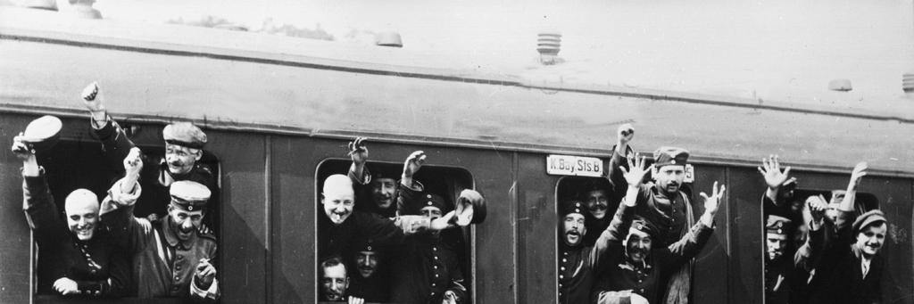 bron 10 Een foto van Duitse soldaten die in augustus1914 naar het front vertrekken: Toelichting: Op de wagon staat onder andere: "Van München via Metz naar Parijs" en "Slaapwagen met Münchner HB van