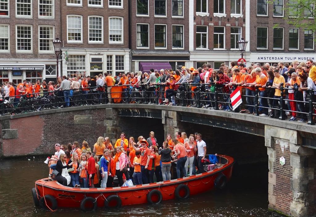 1. Heel Nederland is oranje! 1. Bekijk de foto en praat met je begeleider. Wat zie je op de foto? Welke dag is het denk je? Wie zijn de mensen op de boot?
