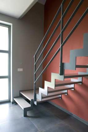 Deze rechte trap met kwartdraaiend bordes bestaat uit een draagstructuur van staal bestaande uit twee trapbomen in Z-vorm.