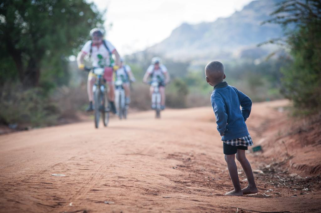 Het fietsen Het terrein van Africa Classic is afwisselend. Je fietst over paden van rood zand en gravel, langs palmbomen, over savannes en door suikerrietplantages.