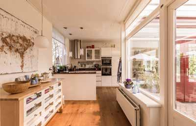 Nu is er een compleet ingerichte, U-vormige witte hoogglans keuken met natuurstenen aanrechtblad. Via de keuken komt u in de multifunctionele ruimte, die nu huishoudelijk en hobbymatig wordt gebruikt.