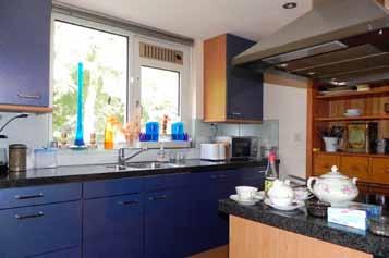 De keuken is voorzien van een kookeiland, granito blad en diverse inbouwapparatuur zoals een vaatwasser, heteluchtoven en koelkast. 2e portaal met tuindeur en trap naar: 1e verd.