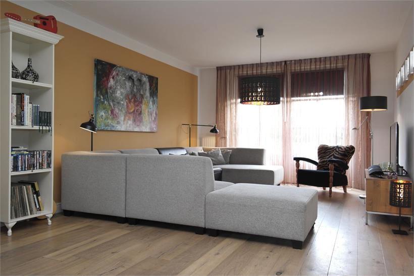 Zeer ruim opgezette woonkamer met een eiken houten vloer met vloerverwarming en vlak stucwerk wanden