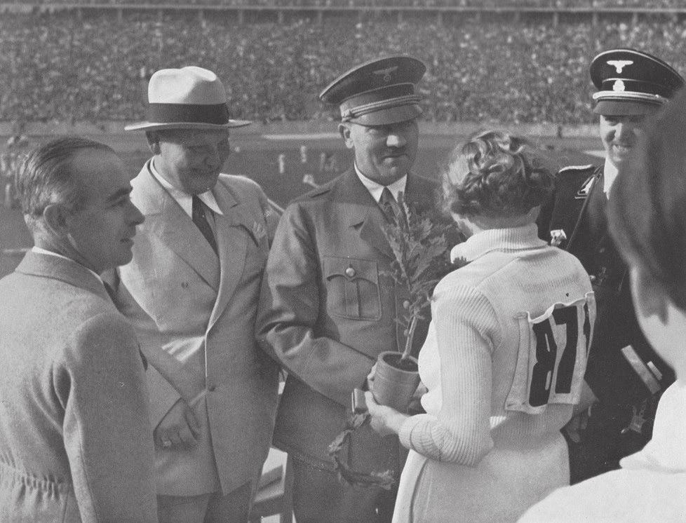 Hitler (met links van hem Hermann Göring and Albert Speer) reikt eik uit aan Olympisch atlete.