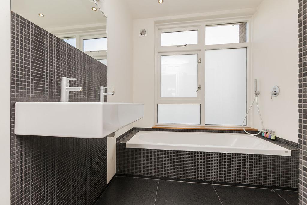 Sanitair De riante badkamer is modern uitgevoerd met
