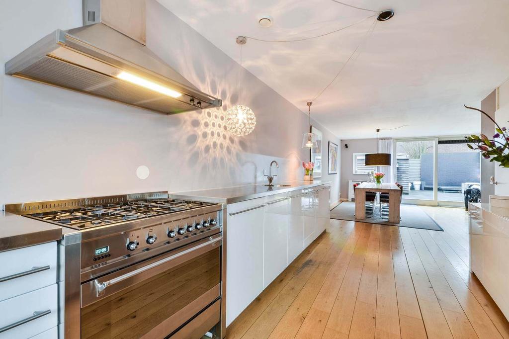De moderne witte hoogglans keuken is voorzien