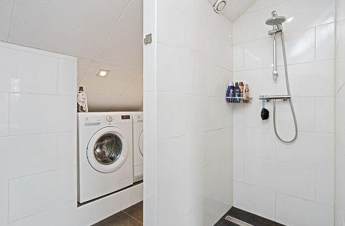 Aan de slaapkamer grenst de vernieuwde badkamer met inloopdouche, wastafelmeubel en kast. Om de hoek is de wasmachine en droger keurig ingebouwd.