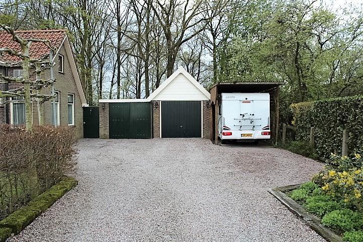 Naast de garage is een carport voor een