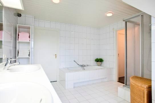 Deze badkamer is uitgevoerd met een toilet, 2 vaste wastafels in meubel, douchecabine en ligbad.