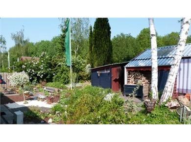 Aan de rechterzijde de woonkamer met weids uitzicht over het water en de tuin.