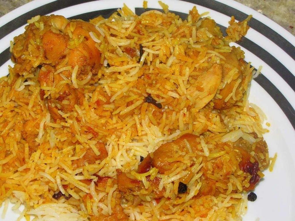 Chicken Biryani Chicken simmered in masala (curry sauce) is added to biryani (aromatic basmati rice cooked in layers with masala /Curry sauce).